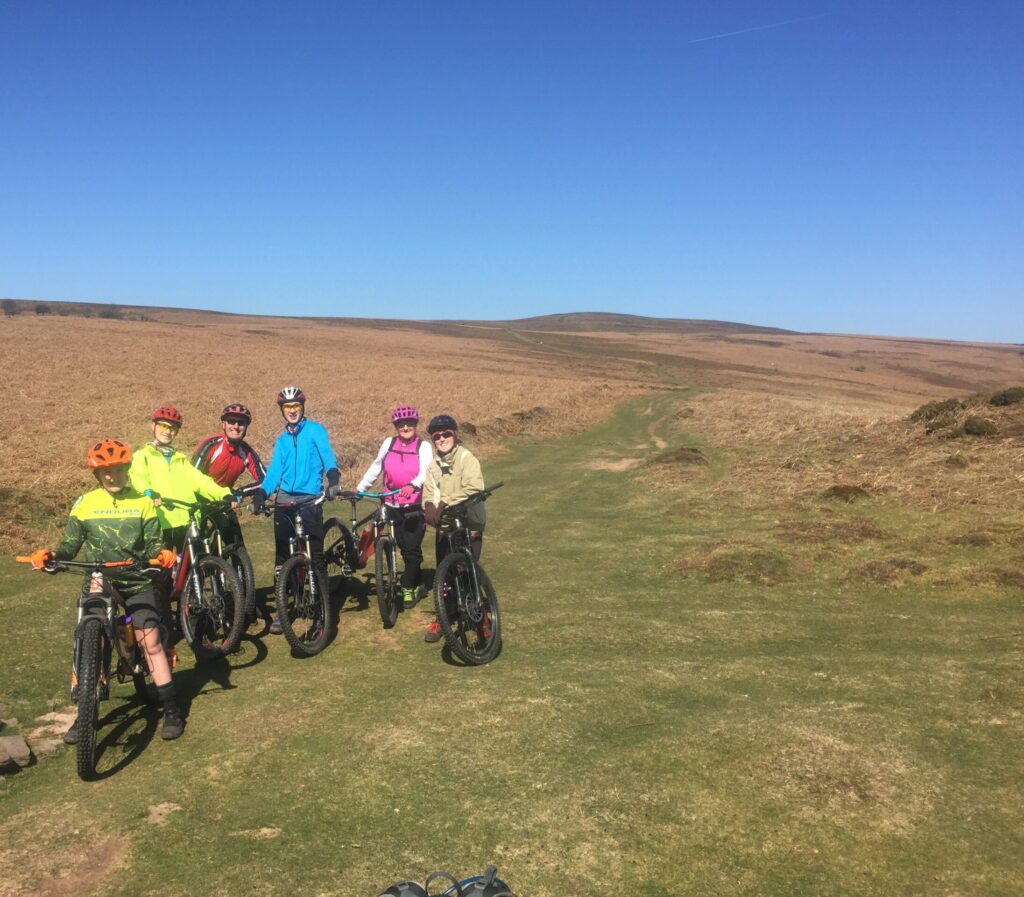 A mixed group of mountain bikers off road in sunny conditions