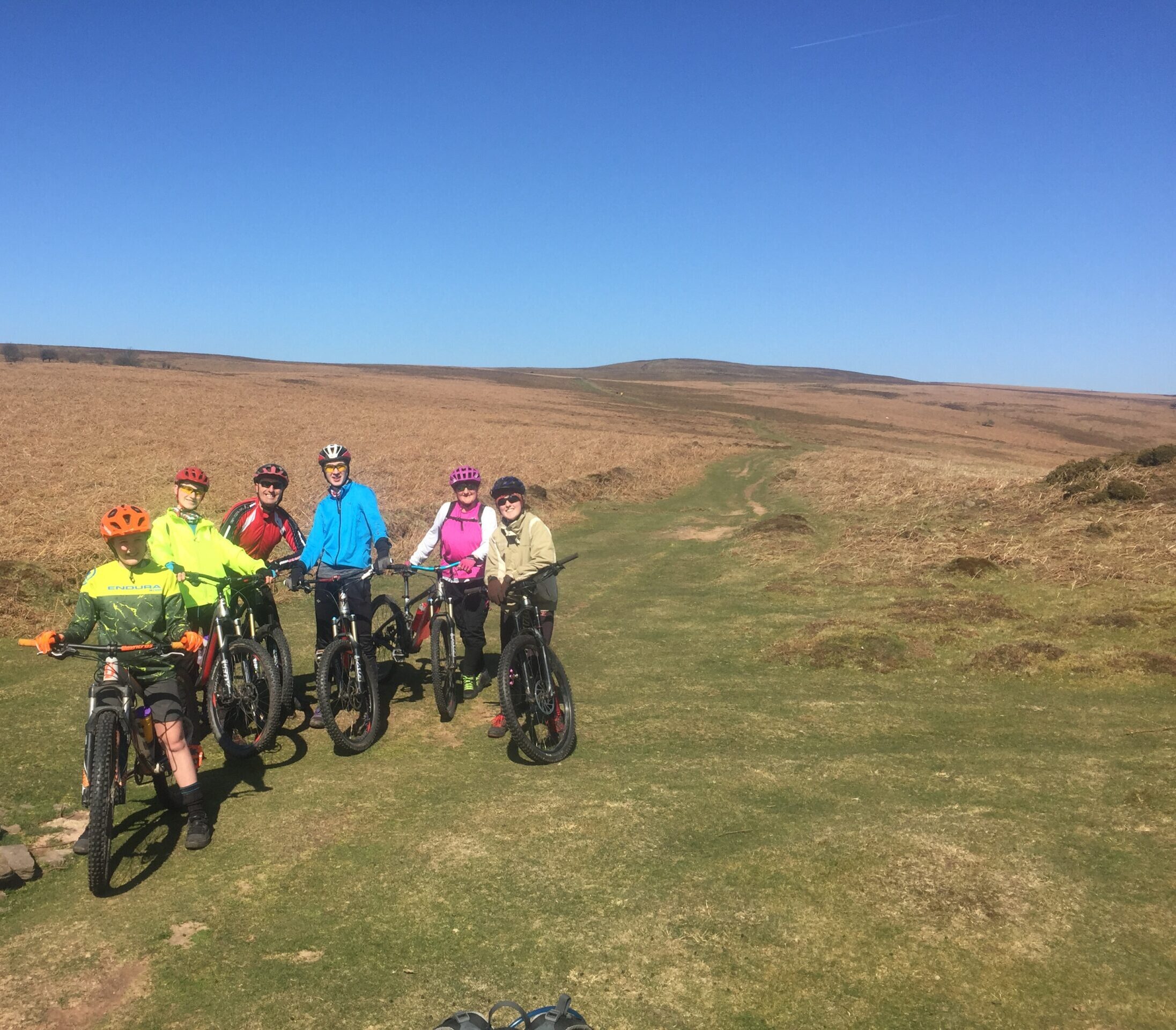 A mixed group of mountain bikers off road in sunny conditions