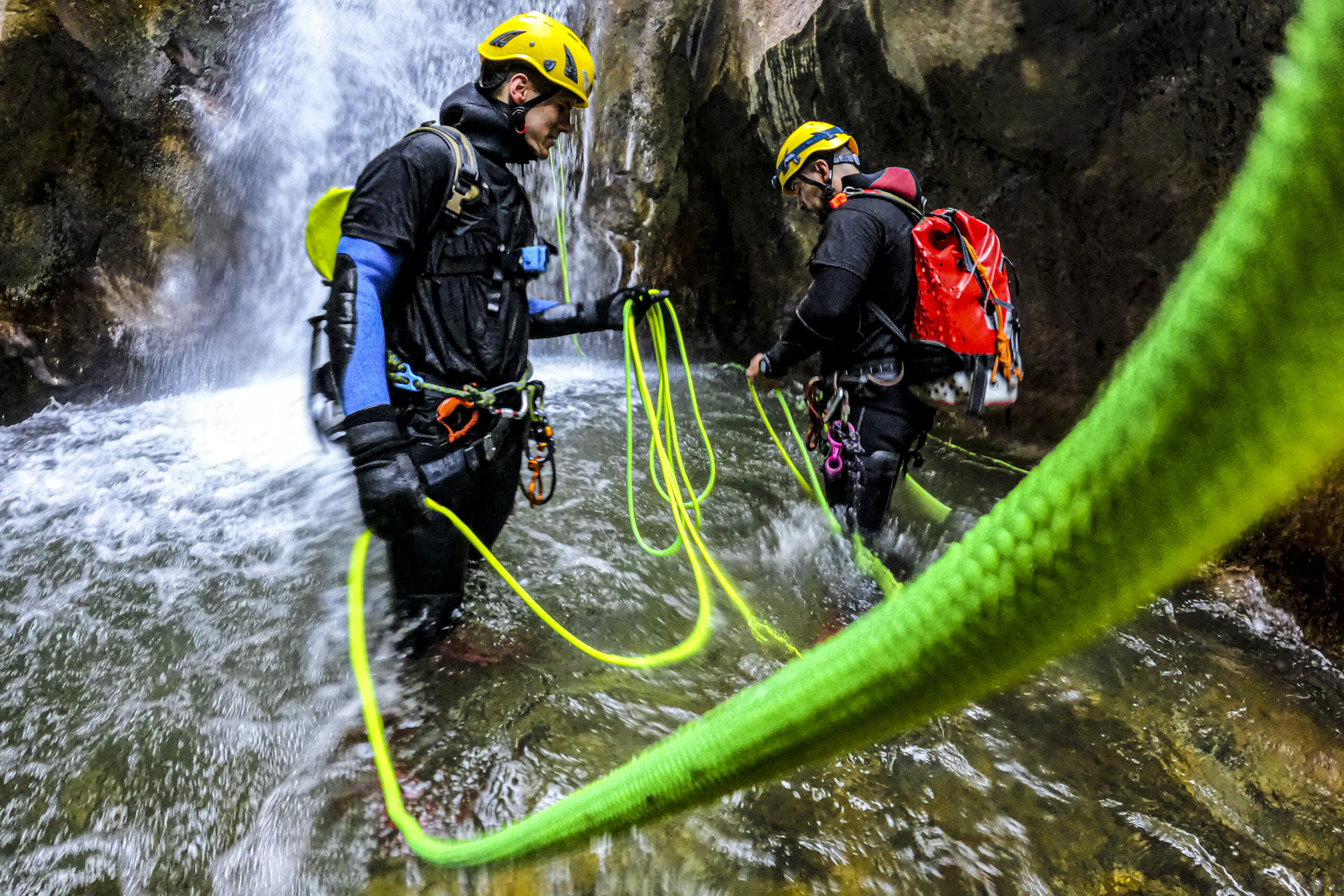 Two canyoneers preparing a rope for next rappelling