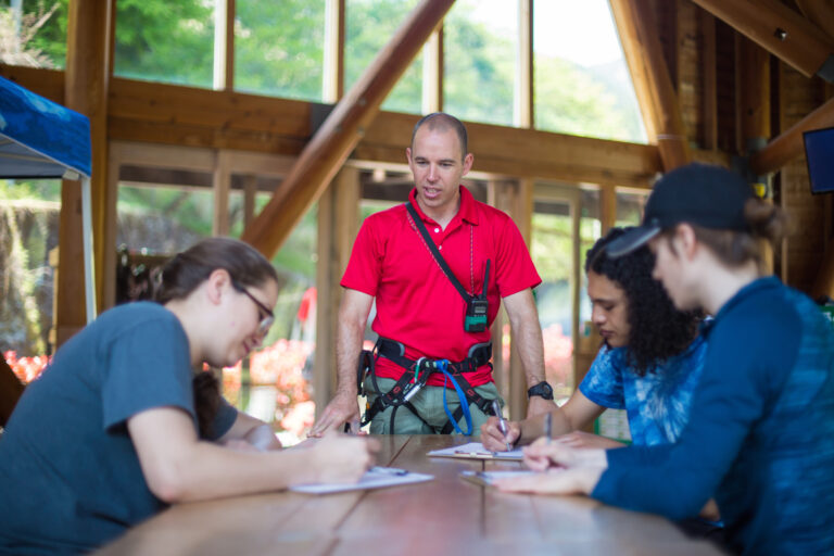 Young people signing waiver documents at an adventure park